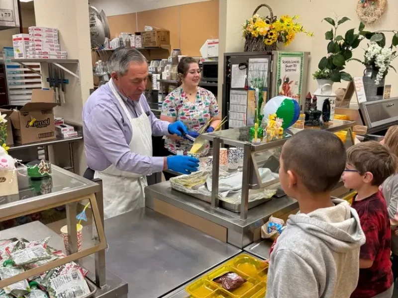 RJ Kost serving food to local students, showing community involvement and support for youth