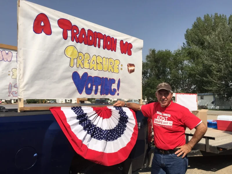 RJ Kost beside campaign display promoting voting and Wyoming traditions