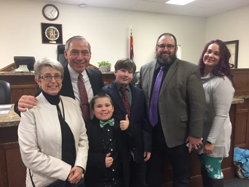 RJ Kost with family in a courthouse setting, reflecting public service and community ties